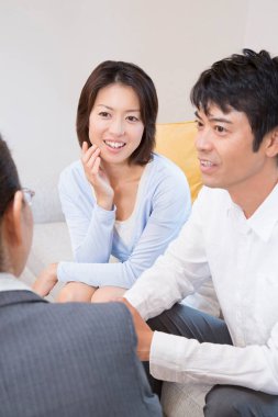 Gülümseyen çift danışmanla önemli konuları tartışıyor.