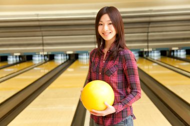Elinde bowling topu tutan Asyalı kadın.