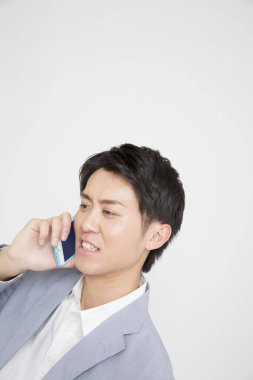 Asyalı işadamı cep telefonuyla konuşuyor