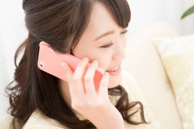 Akıllı telefondan konuşan gülümseyen Asyalı kadın, yakın plan portre 