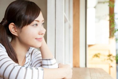 Pencere kenarında oturan genç bir kadın. 