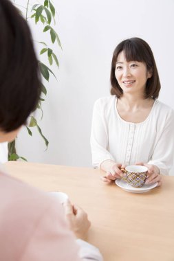 Asyalı kadınlar evde kahvaltı yapıyor.