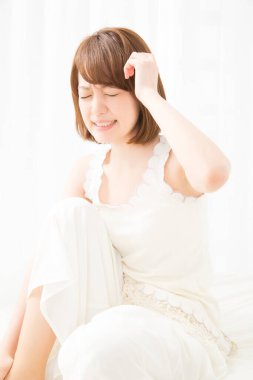 Sabah yatakta başı ağrıyan bir kadın.