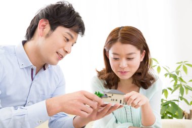 Minyatür ev modelini evde inceleyen çift