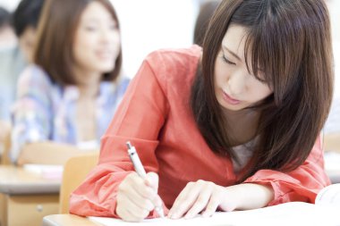 Ders sırasında not yazan genç bir kadın.