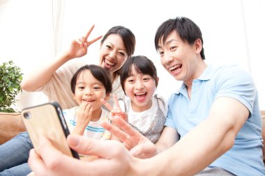 Gülümseyen aile içeride neşeli bir selfie çekiyor.