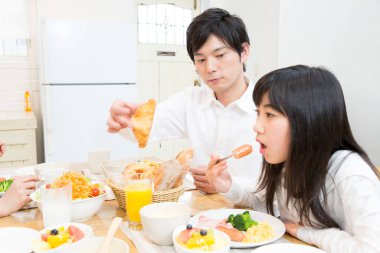 Aile, mutfak masasında kahvaltıyı birlikte yiyor.