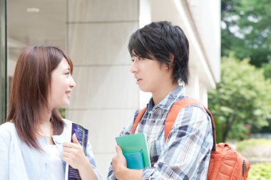 Kitapları olan Asyalı çift öğrencileri