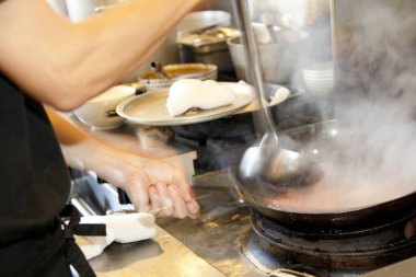 Şef mutfakta lezzetli yemekler hazırlıyor.