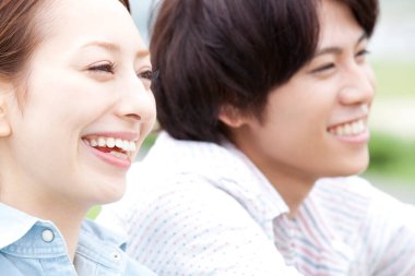 Genç aşık çift dışarıda gülümsüyor.