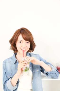 Güzel Japon kadın naneli ferahlatıcı soğuk içecek içiyor.