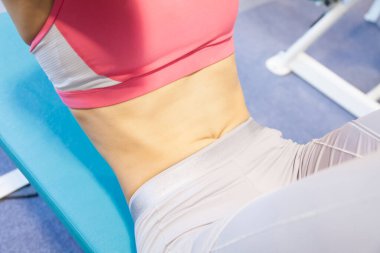 Spor salonunda çalışan bir kadının göbeğini kapat.