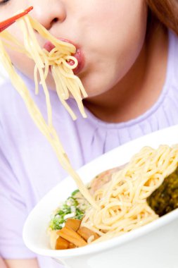 Şişman Asyalı kadın erişte yiyor. Stüdyo resmi