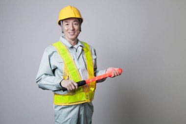 Beyaz arka planda izole edilmiş Asyalı bir inşaat işçisinin stüdyo fotoğrafı.