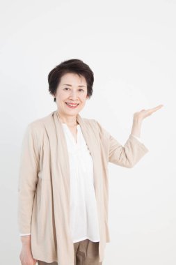 Yetişkin Asyalı Japon kadının beyaz arka planda el ele tutuşurken çekilmiş bir fotoğraf.