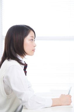 Asyalı genç kadın yakından çalışıyor.