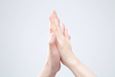 Beyaz arka planda el hareketi yapan kadınların yakın çekimi. 