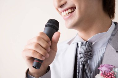 Mikrofonlu genç Asyalı damat, stüdyo fotoğrafı. 