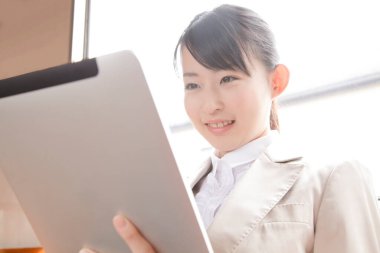 Tablet kullanan genç bir kadın.