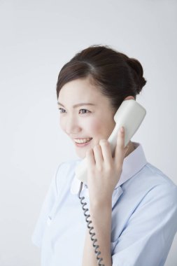 Beyaz arka planda telefon kullanan Japon kadın.