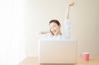 Dizüstü bilgisayarın önünde oturan yorgun kadın.