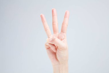 Beyaz arka planda el hareketi yapan kadınların yakın çekimi. 