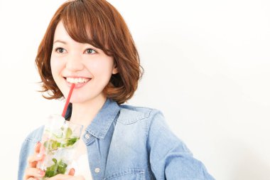 Güzel Japon kadın naneli ferahlatıcı soğuk içecek içiyor.