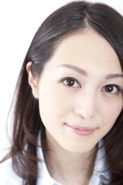 Genç Asyalı iş kadını kameraya bakıyor, beyaz tenli. 