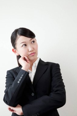 Asyalı iş kadını düşünüyor ve yan bakıyor