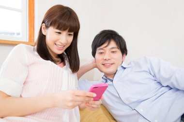 Evde cep telefonu olan genç çift. 