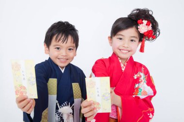 Geleneksel Japon kıyafetleri içinde gülümseyen çocuklar.