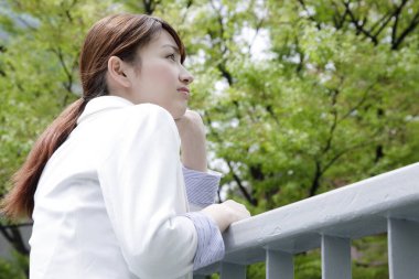 Parktaki Asyalı kadın başka tarafa bakıyor.