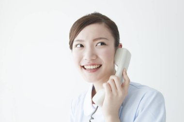 Beyaz arka planda telefon kullanan Japon kadın.