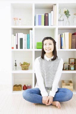 Asyalı kadın odada dinleniyor.