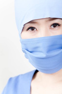 Kadın Asyalı doktor cerrahi maske takıyor