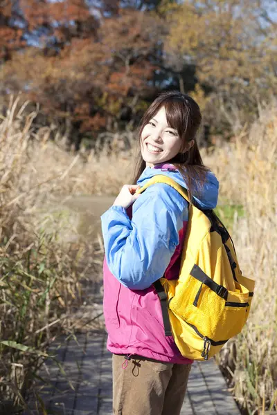 秋の公園でトレッキング黄色のバックパックを持つ若い日本人女性 — ストック写真