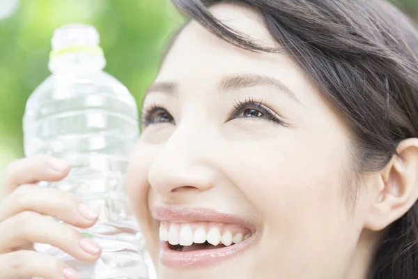 asian woman drinking a water bottle