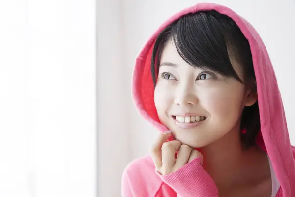 亚洲少女身穿粉色帽衫在家中摆姿势的肖像 — 图库照片