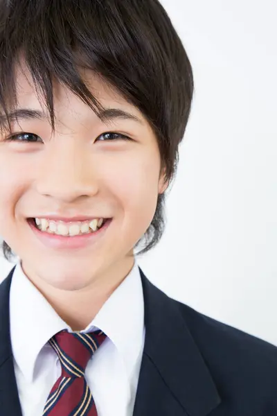stock image Portrait of Japanese teenager in uniform standing on white studio background 