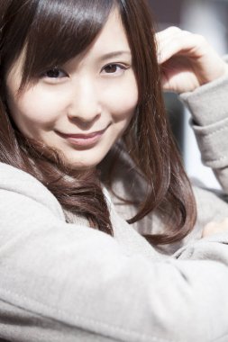 Genç ve güzel Asyalı bir kadının açık hava portresini kapat.