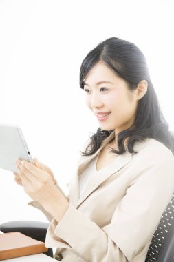 Ofiste tablet bilgisayar kullanan genç bir kadın. 