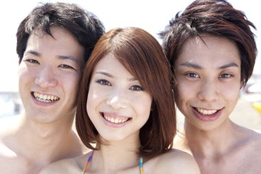 Sahilde eğlenen Asyalı arkadaşların portresi. 