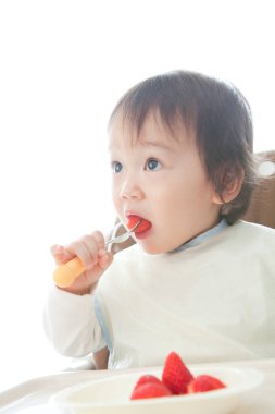 Küçük şirin bebek çilek yiyor.