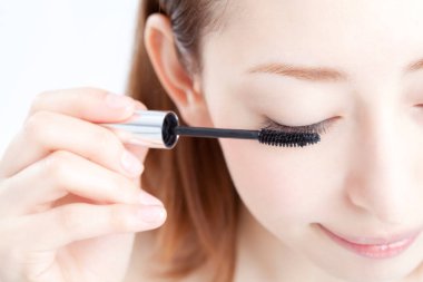 Maskara süren genç bir kadın.