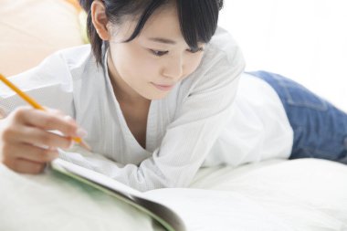 young woman studying in bedroom