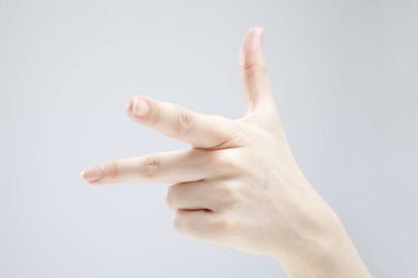 Beyaz arka planda el hareketi yapan kadınların yakın çekimi. 