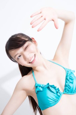 Beyaz arka planda mavi mayo giyen Japon kızın stüdyo portresi. 