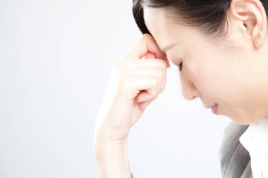 Baş ağrısı olan Asyalı genç bir kadın.