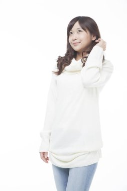 Beyaz arka plan üzerinde beyaz kazaklı genç Asyalı kadın