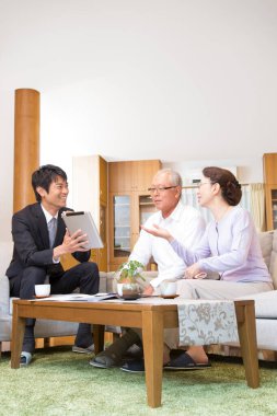 Gülümseyen danışman yaşlı çiftle evde buluşuyor.